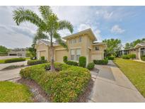 Charming home featuring a well-manicured lawn, beautiful shrubbery, and a lovely palm tree at 1916 Inverness Greens Dr, Sun City Center, FL 33573