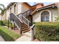Charming condo featuring a private entrance with staircase, complemented by well-maintained landscaping and architectural design at 2636 Enterprise E Rd # C24, Clearwater, FL 33759