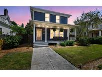 Charming two-story home featuring a covered front porch with seating and manicured landscaping at 2807 N Morgan St, Tampa, FL 33602