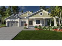 Inviting two-story home with a covered front porch, lush landscaping, and an attached two-car garage at 3207 Lake Padgett Dr, Land O Lakes, FL 34639