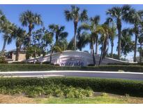 Waterside community entrance with lush landscaping, palm trees, and decorative signage under a clear blue sky at 4794 Cobia Se Dr # D, St Petersburg, FL 33705