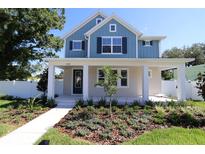 Charming two-story home with a blue exterior and a beautifully landscaped front yard at 5235 9Th N Ave, St Petersburg, FL 33710