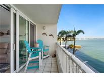 Relaxing balcony featuring blue chairs, palm trees, and a beautiful waterfront view at 5279 Isla Key S Blvd # 212, St Petersburg, FL 33715