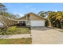 Charming single-story home featuring a well-manicured lawn, two-car garage, and beautiful landscaping at 15838 49Th N St, Clearwater, FL 33762
