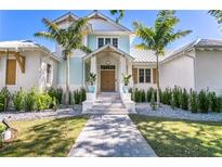 Charming coastal home featuring a welcoming entryway, manicured landscaping, and a light blue facade at 1695 Brightwaters Ne Blvd, St Petersburg, FL 33704