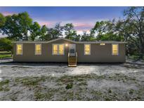 Charming tan single-story home with wood steps leading to the front door at 17913 Greensboro St, Spring Hill, FL 34610