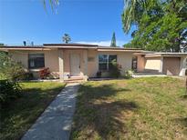 Charming single-story home featuring a well-maintained lawn, mature trees, and inviting front entrance at 204 Shore W Dr, Oldsmar, FL 34677