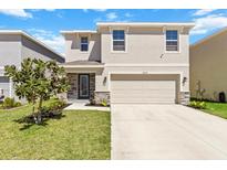 Charming two-story home with a well-maintained lawn, stone accents, and attached two-car garage at 36541 Night Strawberry Ct, Dade City, FL 33525