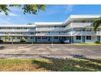 Three-story condo building with parking and a blue exterior with white lattice balconies under a partly cloudy sky at 4720 Locust Ne St # 206, St Petersburg, FL 33703