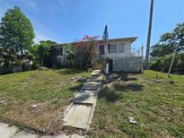 Modest home featuring a small porch with landscaping and a walkway leading to the entrance at 613 Chestnut St, Oldsmar, FL 34677