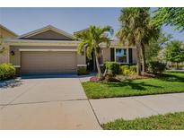 Charming home with a two-car garage, mature landscaping, and beautiful curb appeal on a sunny day at 6312 Lantern View Pl, Apollo Beach, FL 33572
