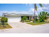 Charming one-story home featuring a well-manicured lawn, inviting walkway, and an attached two-car garage at 7321 San Moritz Dr, Port Richey, FL 34668