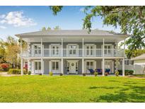 Stunning two-story home with a grand facade, featuring a spacious balcony, lush lawn, and elegant architectural details at 7352 Hunt Club Ln, Seminole, FL 33776