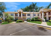 Inviting two-story condo with well-maintained landscaping, two palm trees, and clearly marked parking spots at 7802 Hardwick Dr # 1126, New Port Richey, FL 34653