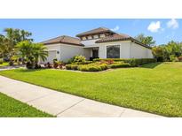 Beautiful single-story home featuring a well-manicured lawn with tropical landscaping and a clay tile roof at 10505 Inglenook Ter, Palmetto, FL 34221