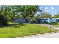 Charming single-story home featuring a well-maintained lawn and mature trees providing ample shade at 1411 Barry St, Clearwater, FL 33756