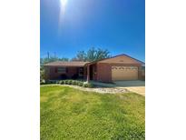 Cozy brick home featuring an attached garage, well-maintained lawn, and a sunny front yard at 1850 Oklahoma Ne Ave, St Petersburg, FL 33703