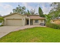 Charming single-Gathering home featuring a well-manicured lawn and an attached two-car garage at 2812 Ormandy Ct, Tampa, FL 33618