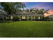 Charming single-story home with lush green lawn, black shutters, and mature landscaping at 4214 W Beach Park Dr, Tampa, FL 33609