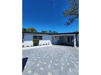 Charming single-story home featuring a white exterior, covered entry, and gray brick driveway at 4619 Helena Ne St, St Petersburg, FL 33703