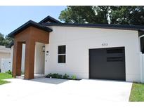 Contemporary home boasts a sleek garage door, modern lighting and a minimalist, landscaped yard at 5518 Newton S Ave, Gulfport, FL 33707