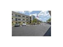 Well-maintained building with ample parking, trees, and an American flag flying in the breeze at 5990 Terrace Park N Dr # 109, St Petersburg, FL 33709