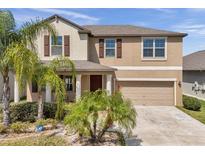 Inviting two-story home featuring a well-manicured lawn and an attached two-car garage at 11820 Sunburst Marble Rd, Riverview, FL 33579