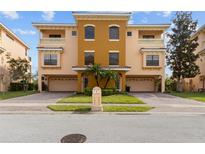 Beautiful multi-level townhome with a two-car garage, manicured landscaping, and private balcony at 1537 Ember Ln, Tarpon Springs, FL 34689