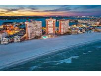 Stunning aerial view of beachfront condo towers with city skyline and ocean sunset backdrop at 17920 Gulf Blvd # 2004, Redington Shores, FL 33708