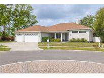 Charming home featuring a three-car garage, well-maintained lawn, and mature trees in a serene neighborhood at 3027 Key Harbor Dr, Safety Harbor, FL 34695