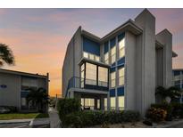 Beautiful 3-story condo building with blue trim and lots of large windows at dusk at 315 Medallion Blvd # E, Madeira Beach, FL 33708
