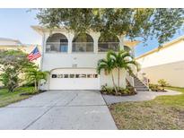 Charming two-story home with a garage, balcony, and landscaped yard at 6311 Bayside Dr, New Port Richey, FL 34652
