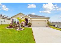 Charming one-story home featuring a manicured lawn and a two car garage at 6882 Silverado Ranch Blvd, Zephyrhills, FL 33541