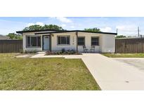 Charming single-story home with a well-manicured lawn and a concrete driveway at 7520 Orpine N Dr, St Petersburg, FL 33702