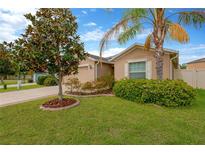 Charming single story home boasts beautiful landscaping, lawn, and palm tree at 8529 Hunters Fork Loop, Ruskin, FL 33573