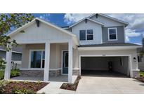 Charming two-story home featuring a welcoming front porch and an attached two-car garage at 11884 Richmond Trl, Parrish, FL 34219