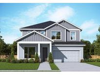 Two-story home featuring a modern design, well-manicured lawn, and integrated two-car garage at 11884 Richmond Trl, Parrish, FL 34219