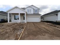 New construction home showcasing a two-car garage and covered front porch at 11884 Richmond Trl, Parrish, FL 34219