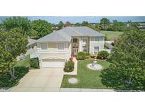 Beautiful two-story home features a well-manicured lawn with mature trees and a charming water fountain feature at 13122 Prestwick Dr, Riverview, FL 33579