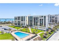 Expansive condo complex with a refreshing outdoor pool, manicured lawns, and scenic waterfront views at 1430 Gulf Blvd # 309, Clearwater Beach, FL 33767