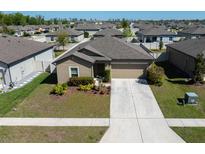Charming single-story home with a two-car garage, well-manicured lawn, and beautiful landscaping at 18715 Alfaro Loop Ct, Spring Hill, FL 34610