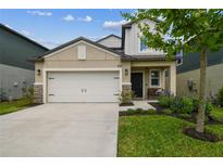 Charming home featuring a two-car garage, stone accents, and well-maintained landscaping at 22229 Storybook Cabin Way, Land O Lakes, FL 34637