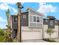 Modern townhome with a two-car garage, gray siding, and attractive landscaping at 3467 Timber Crossing Ave, Brandon, FL 33511
