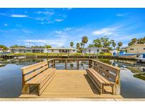 Waterfront homes with private dock on a sunny day with benches, providing access to the water at 4061 13Th Ne Ln, St Petersburg, FL 33703