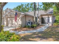 Charming home featuring a two-car garage, manicured landscaping, and an inviting entrance at 5245 Lochmead Ter, Zephyrhills, FL 33541