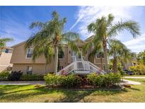 Two-story home featuring a well-manicured lawn and decorative palm trees at 7345 Brightwaters Ct, New Port Richey, FL 34652