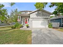 Charming home featuring well-manicured lawn, paved driveway, and inviting red front door at 7417 S Morton St, Tampa, FL 33616