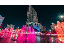 Night view of a modern high-rise building with vibrant pink fountains in front of it at 777 N Ashley Dr # 2610, Tampa, FL 33602