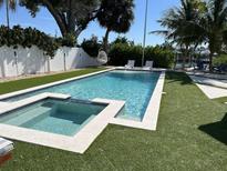 Backyard pool with spa, set in turf with white fence and lounge chairs at 7912 Causeway S Blvd, St Petersburg, FL 33707