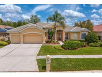 Charming home featuring manicured lawn, tile roof, and three-car garage at 10228 Estuary Dr, Tampa, FL 33647